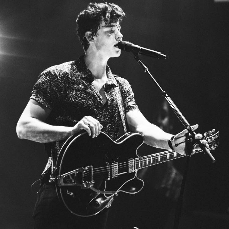 Shawn Mendes playing guitar and singing